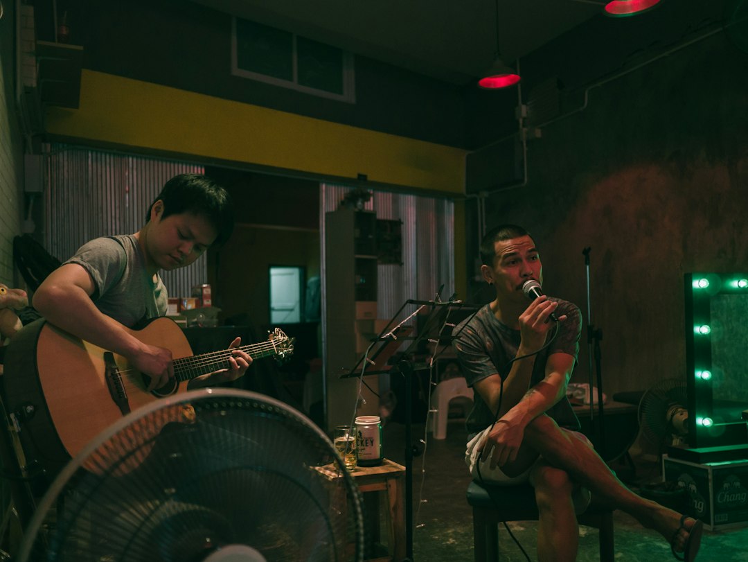 man-singing-beside-man-playing-guitar-uo-5mtf2ihk